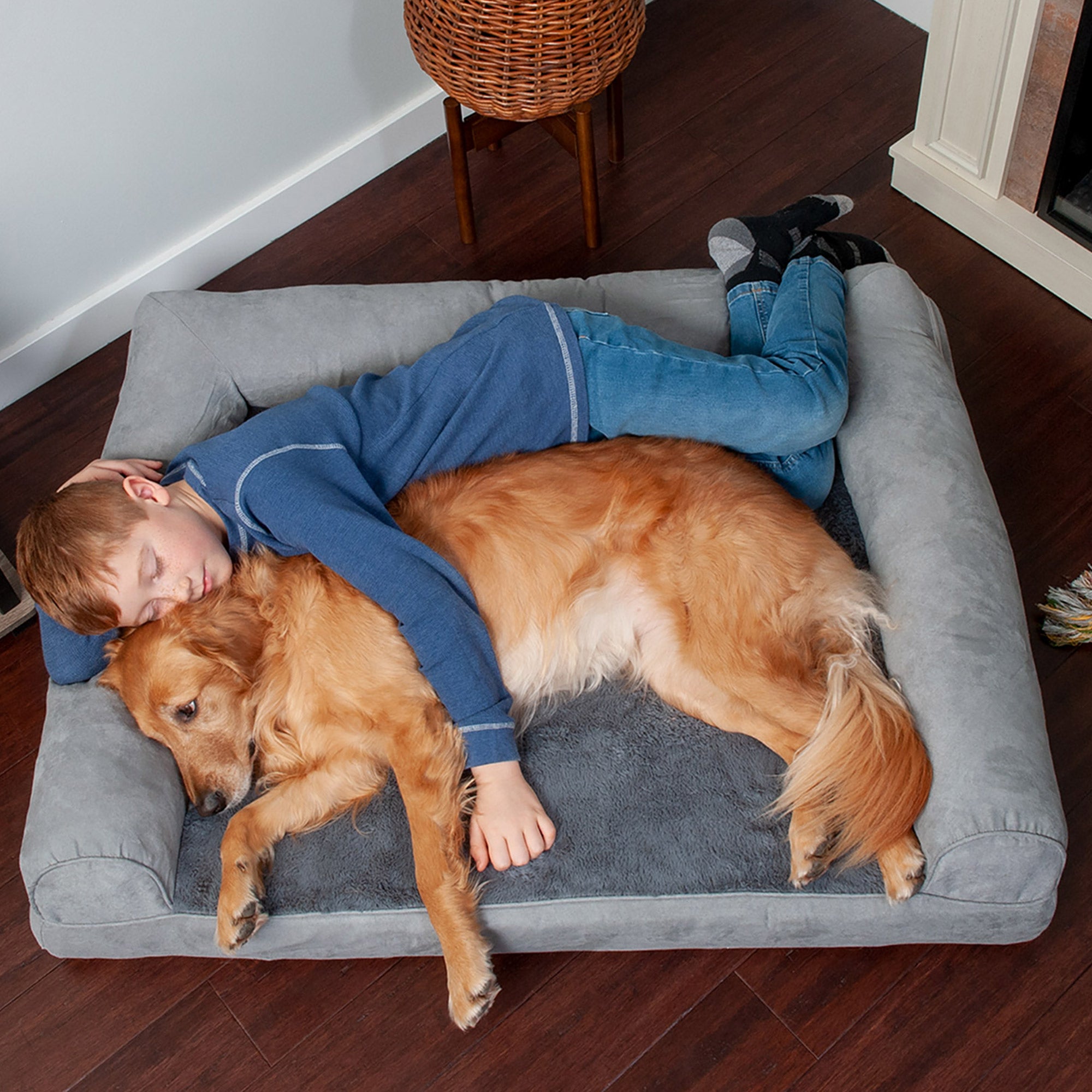 A child and a dog sleeping on a FurHaven brand pet bed 